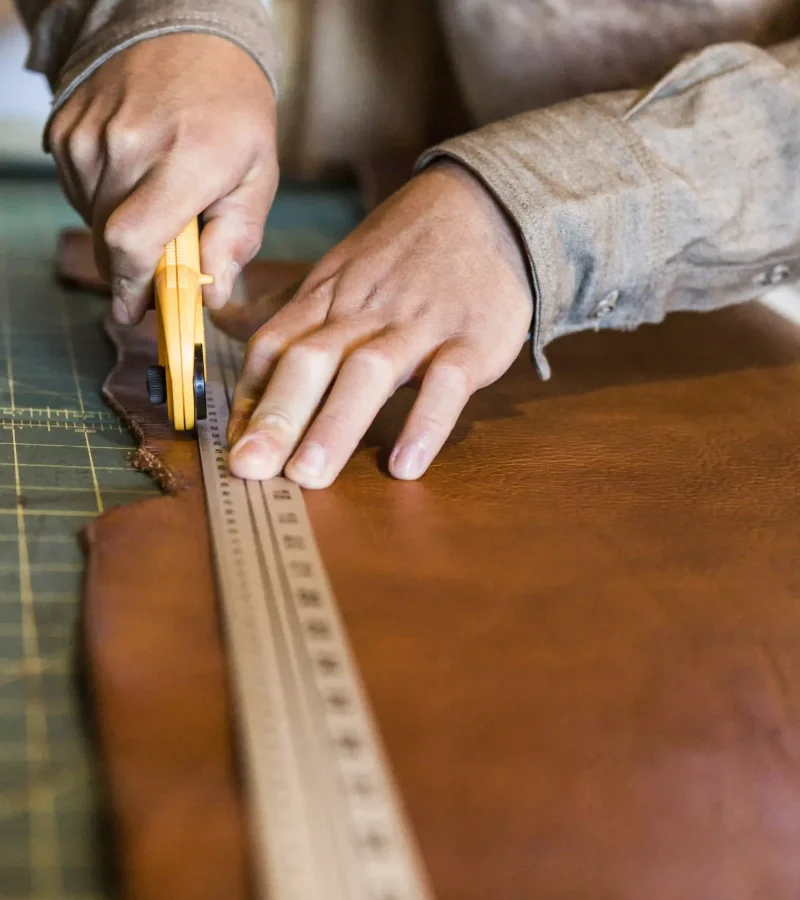 hands-of-leather-craftsman-using-rotary-cutter-on-2023-11-27-05-32-44-utc (1)